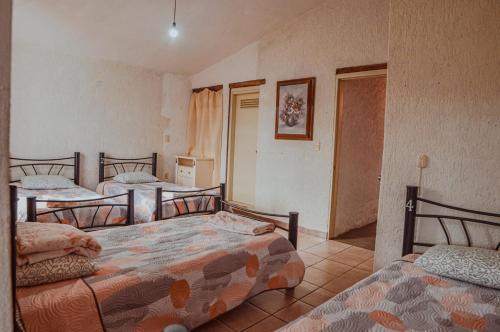 1 Schlafzimmer mit 3 Betten und einer Tür zu einem Zimmer in der Unterkunft casa79sancris in San Cristóbal de las Casas