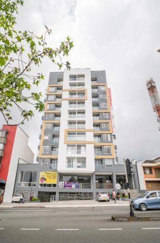 a tall building with cars parked in front of it at UhaUs Coliving 302 - Apto 12 habitaciones in Manizales