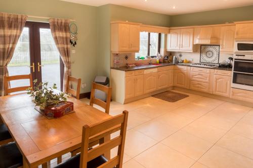 a kitchen with a wooden table and a dining room at Bree House Malin Head in Malin Head