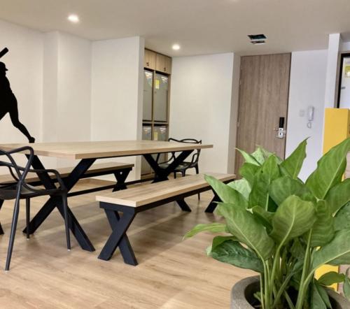 a table and benches in a room with plants at UhaUs Coliving 302 - Apto 12 habitaciones in Manizales