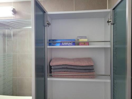 un armario de cristal con toallas y libros en el baño en Yeongtong Family House en Suwon