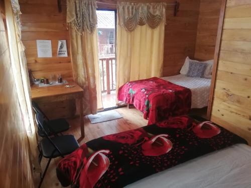 ein Schlafzimmer mit 2 Betten und ein Bad mit einem Fenster in der Unterkunft Cabañas San Gerardo in San Gerardo de Dota