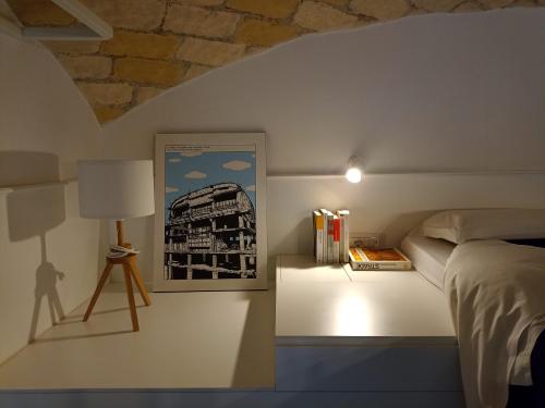 a bedroom with a bed and a lamp and a picture at Tolli Colosseo Apartment in Rome