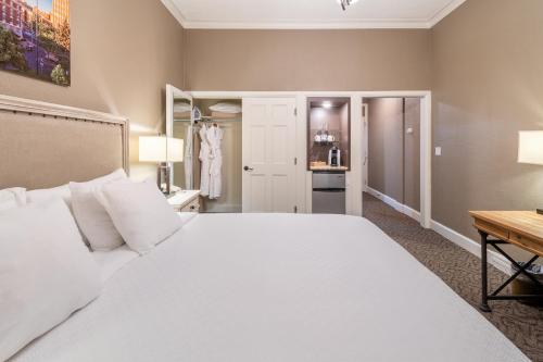 a bedroom with a large white bed and a desk at Spokane Club Hotel in Spokane