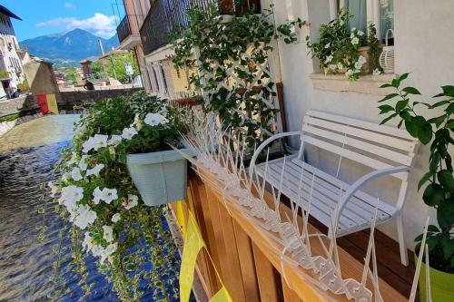 a bench on the side of a building with flowers at Piccola Venezia - Borgo Valsugana in Borgo