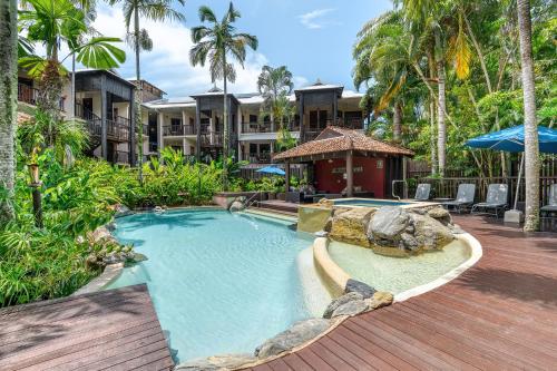 a swimming pool in a resort with palm trees at Poolside Villa - Hibiscus 40b in Port Douglas