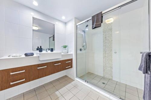 a bathroom with a glass shower and a sink at Whitsunday Wonderview in Airlie Beach