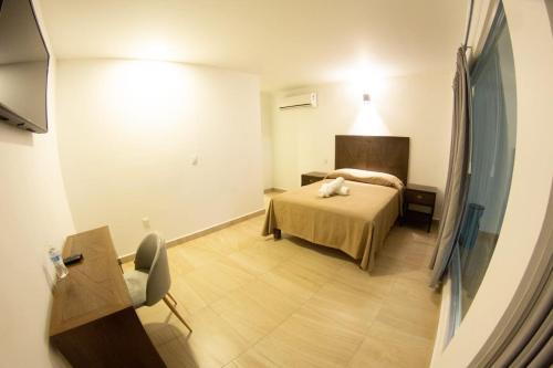 a room with a bed and a desk and a chair at HOTEL REFORMA 14 in Iguala de la Independencia