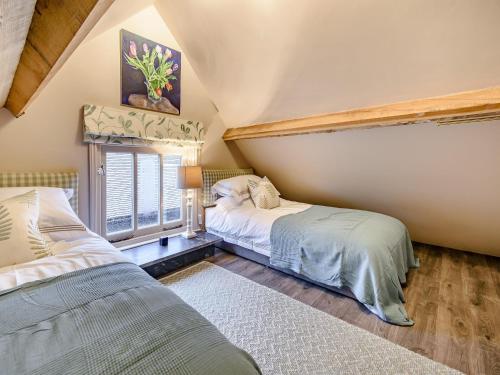 a bedroom with two beds and a window at The Barn in Uckfield