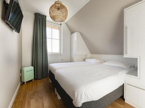 Un dormitorio con una cama grande y una ventana en Luxury villa with gas fireplace, on a holiday park on the Tjeukemeer, en Delfstrahuizen