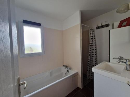 bagno con vasca, lavandino e finestra di Holiday Home Pleubian - BRE02104c-F a Pleubian