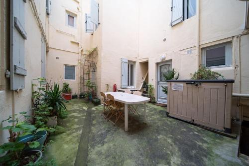 a courtyard with a table and chairs in a building at Studio Premium City center in Chalon-sur-Saône