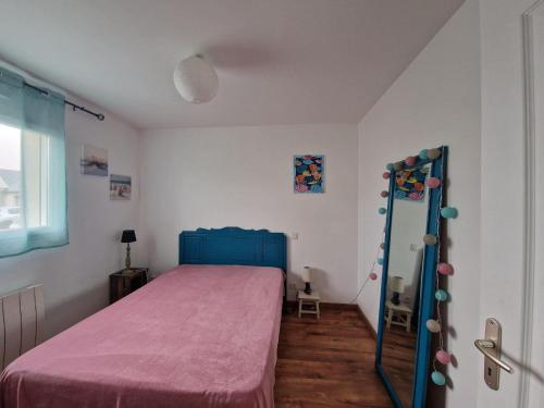 una camera con letto blu e specchio di Holiday Home Pleubian - BRE02104c-F a Pleubian