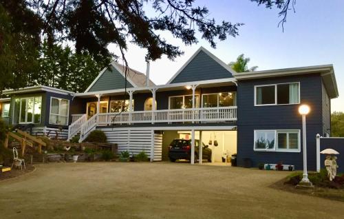 a large blue house with a large driveway at Hamptons In Rye Studio - 3 Mins from Famous Hot Springs! in Rye