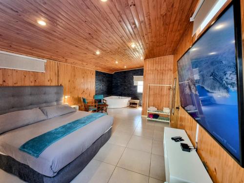 1 dormitorio con cama, bañera y TV en Reñaca House Bed & Breakfast, en Viña del Mar