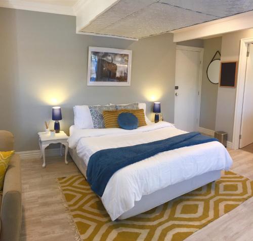 een slaapkamer met een groot bed met 2 tafels en 2 lampen bij Hamptons In Rye Studio - 3 Mins from Famous Hot Springs! in Rye