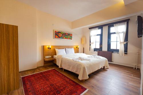a bedroom with a bed and a red rug at Simre Inn Hotel Safranbolu in Safranbolu