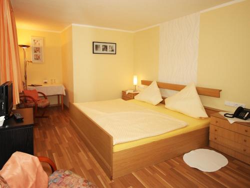 um pequeno quarto com uma cama e um telefone em Landhotel Weinrich em Naumburg
