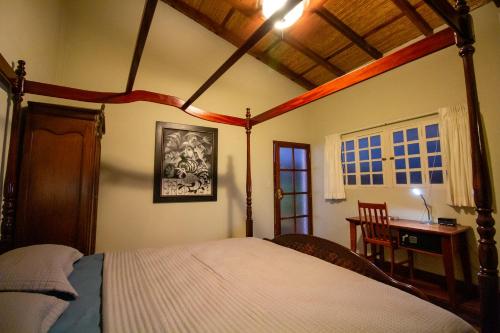 a bedroom with a bed and a desk and a window at Hotel La Calzada in Granada