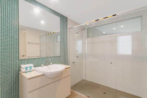a bathroom with a sink and a glass shower at Deluxe Dual-Key Apartment in Peppers @ Salt Resort by uHoliday (3BR, 2BR and Hotel Room Options Available) in Kingscliff