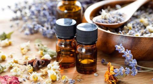 three bottles of essential oils next to a bowl of flowers at Hamptons In Rye Studio - 3 Mins from Famous Hot Springs! in Rye