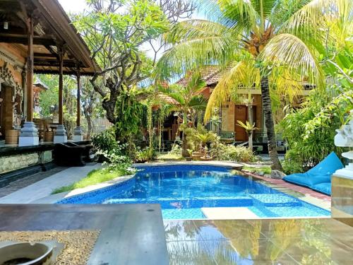 a pool in the backyard of a house with palm trees at Green Palace Homestay in Nusa Penida