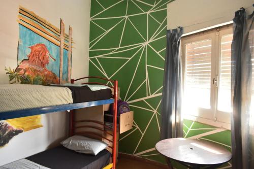 Ce dortoir dispose de lits superposés et d'une fenêtre. dans l'établissement Hostel Joven casa Reggae, à Córdoba