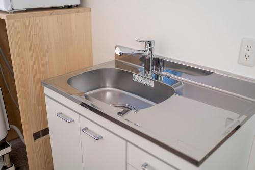 a stainless steel sink in a small kitchen at RESI STAY Jisco Hotel Kyoto Goshonishi in Kyoto