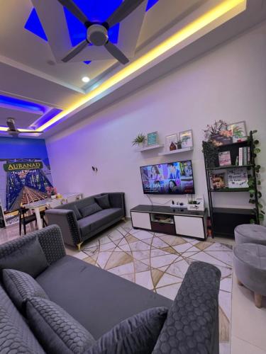 Auranad Guest House Tanah Merah Wifi-Netflix في Kampong Tanah Merah: غرفة معيشة مع كنب وتلفزيون بشاشة مسطحة