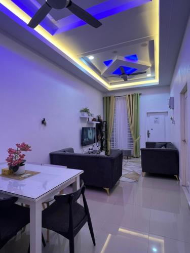 Auranad Guest House Tanah Merah Wifi-Netflix في Kampong Tanah Merah: غرفة معيشة مع أريكة وطاولة