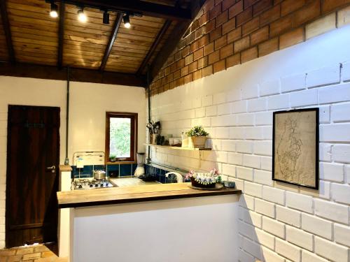 una cucina con un lavello e un muro di mattoni di Casa a 100 mts da praia! a Garopaba