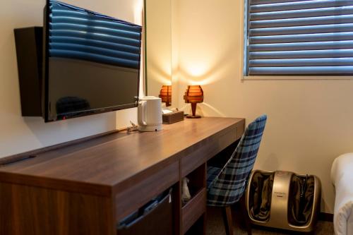 a bedroom with a desk with a mirror and a tv at RESI STAY Jisco Hotel Kyoto Goshonishi in Kyoto