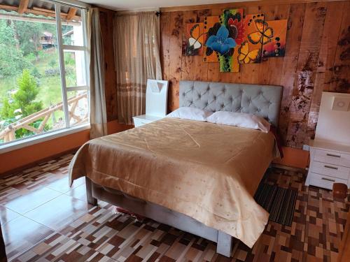 1 dormitorio con cama y ventana grande en Cabaña de descanso arcoiris del lago 3, en Pasto
