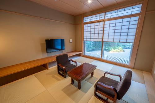 a waiting room with a table and chairs and a tv at RESI STAY Jisco Hotel Kyoto Goshonishi in Kyoto