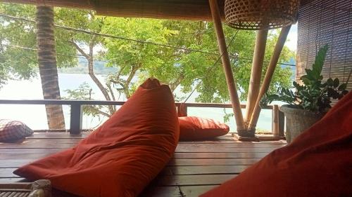 a large pillow sitting on a porch with a window at Tanjungan in Gili Gede
