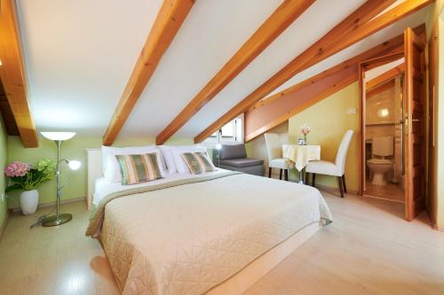 トロギールにあるApartments and rooms by the sea Trogir - 16844のベッドルーム1室(大型ベッド1台付)、ダイニングルームが備わります。