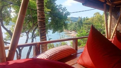 a room with a balcony with a view of the water at Tanjungan in Gili Gede