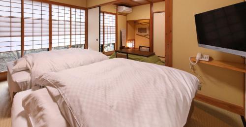 a hospital room with a bed and a flat screen tv at Yamashinobu in Minamioguni