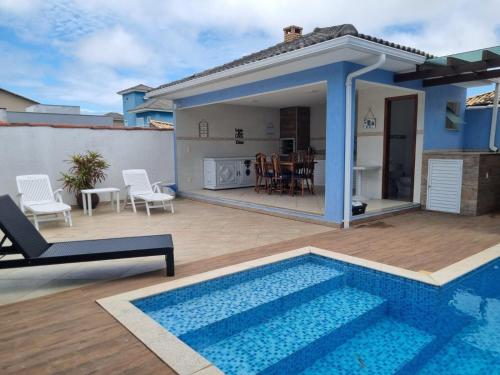 une villa avec une piscine et une maison dans l'établissement Casa Azul - Linda casa Familiar com Piscina no Peró em Cabo Frio, à Cabo Frio