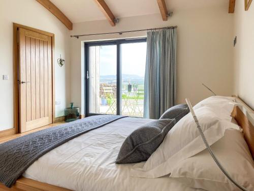 a bedroom with a large bed with a large window at High Trodigal in Machrihanish