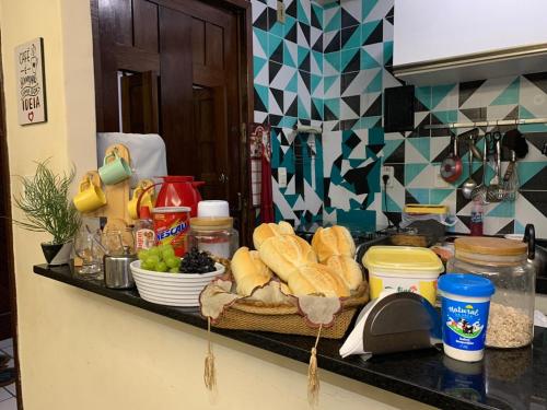 una encimera de cocina con pan y otros alimentos. en Quarto aconchegante na casa de vovó modalidade guest house, en Recife