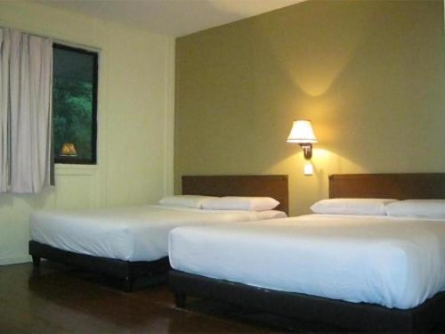 2 bedden in een hotelkamer met een raam bij Eastana Cherating Beach Resort in Cherating