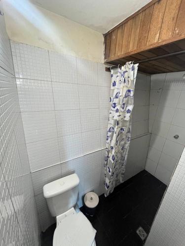 a bathroom with a toilet and a shower curtain at Bem Me Quer Casas in Morro de São Paulo