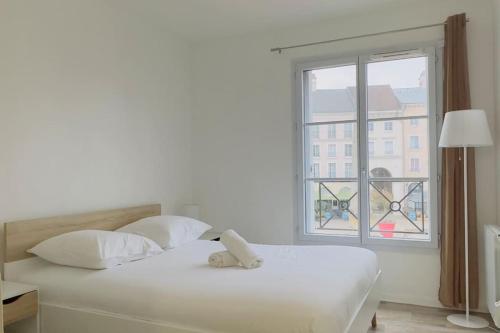 une chambre blanche avec un lit et une fenêtre dans l'établissement 1 Bedroomed Toscane Serris, à Serris