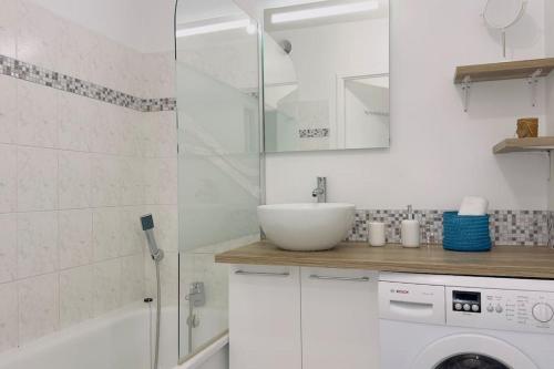 La salle de bains blanche est pourvue d'un lavabo et d'un lave-linge. dans l'établissement 1 Bedroomed Toscane Serris, à Serris
