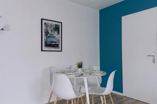 une salle à manger avec une table blanche et des chaises blanches dans l'établissement 1 Bedroomed Toscane Serris, à Serris