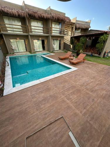 a swimming pool in front of a house at Nauru Chalés Milagres in São Miguel dos Milagres