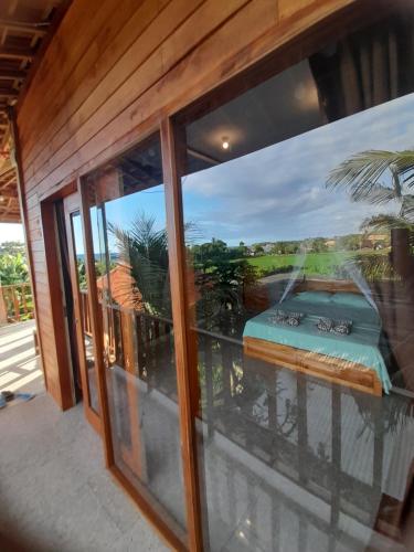 a room with a window with a bed on a balcony at THE NYAMO surf & stay in Pulukan