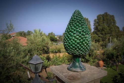 a statue of a pineapple sitting on top of a garden at Avocado B&B Beyond in Giardini Naxos