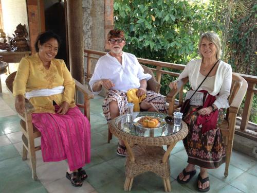 three older people sitting around a table on a porch at Sua Bali in Ubud